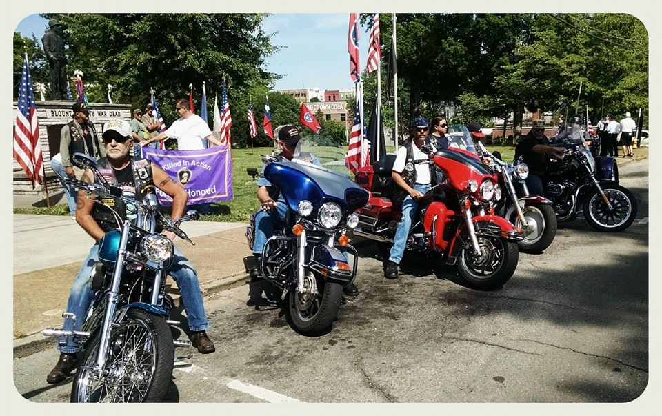 Image of several motorcycles with motorcyclists astride