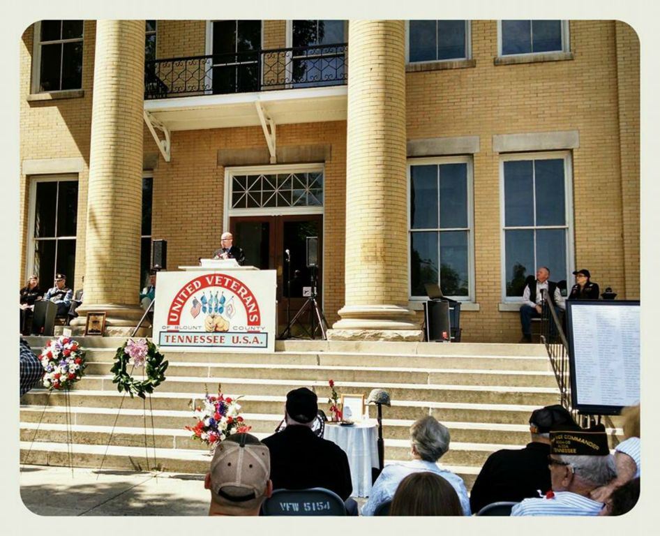 Speaker standing at podium at top of Court House stairs