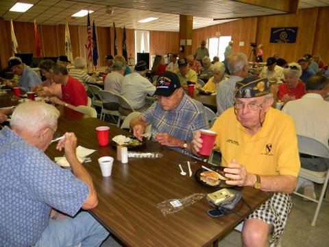 Group picture of veterans and attendees eating 