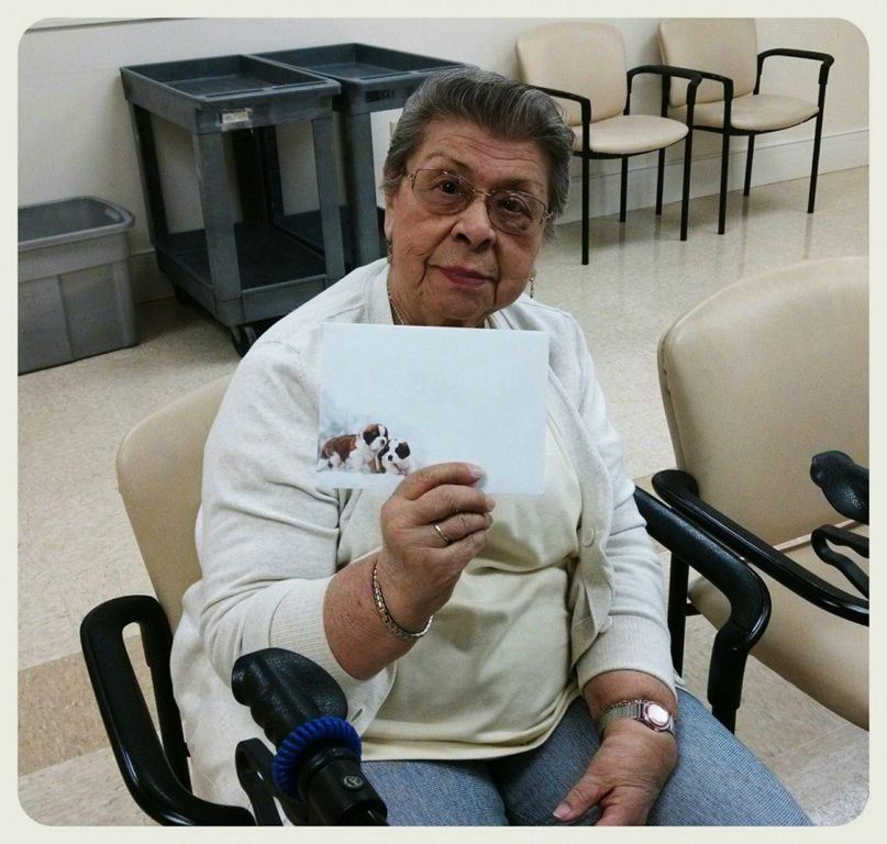 Sittign woman veteran holds up card for camers