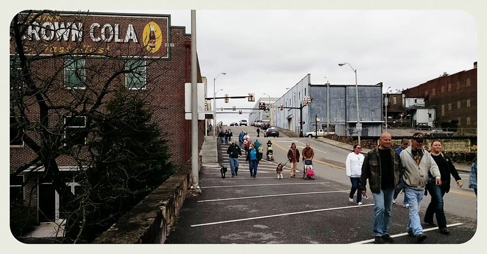 Walking group passing through town, with streets and buildings