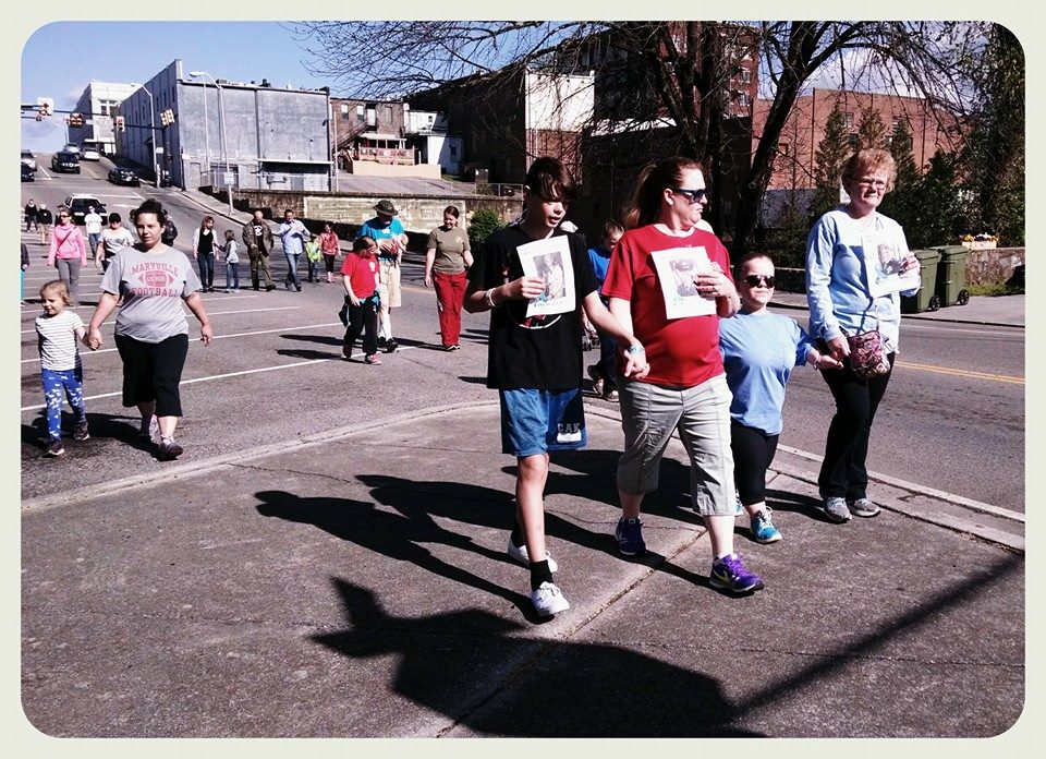 Image of whole group walking down street, with city in background