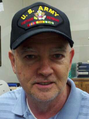 Up close image of man with glasses wearing US Army Vietnam Veteran hat