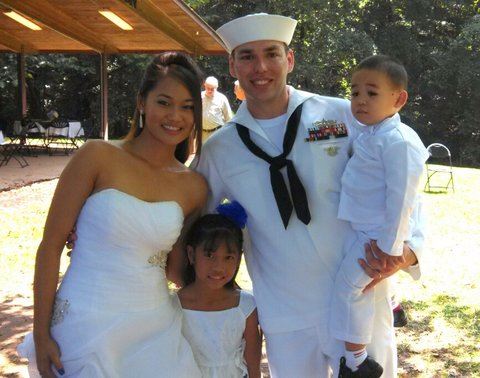 Image of bride in dress, with little girl and navyman in whites holding youg boy