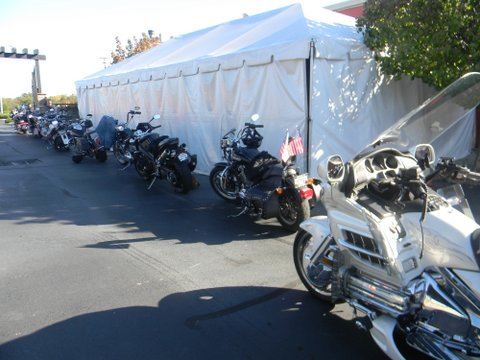 Image of parked motorcycles outside white tent