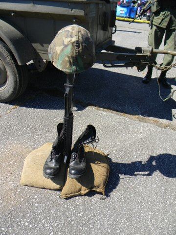 Pair of boots with rifle and helmet in memorial of lost soldiers