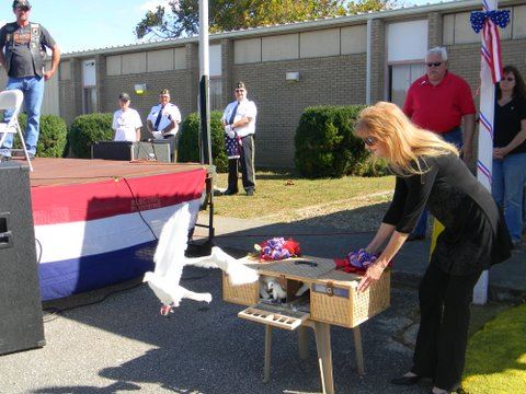 Woman in black dress releases doves from wicker box