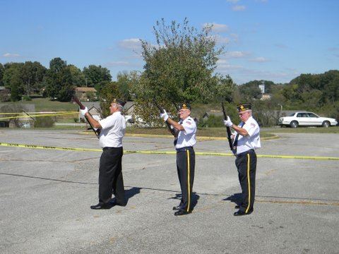 Three men in white shirts with black pants, aiming rifles